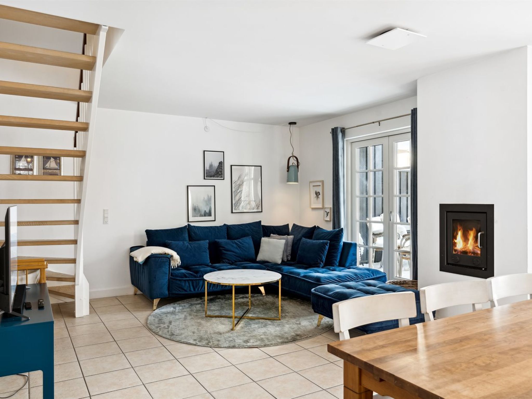 Un salon moderne avec un canapé bleu, une table basse ronde et une cheminée.