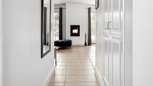 Un couloir avec une cheminée, un banc et une porte sur le côté droit.