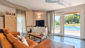 Un salon moderne avec un canapé en cuir, un téléviseur à écran plat et un mur décoratif en pierre.