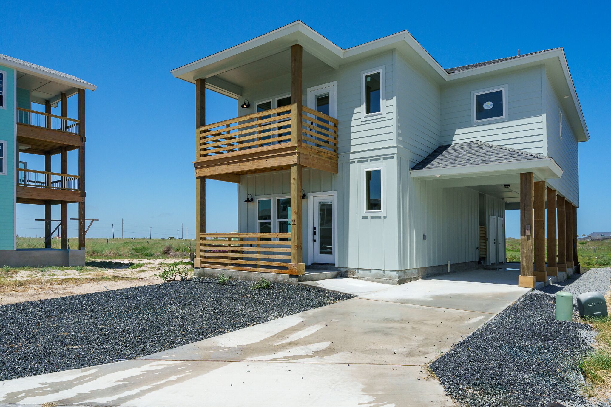 A two-story house with a balcony, a covered porch, and a garage.