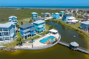 A coastal residential area with houses, a swimming pool, and a dock. - Shared Pool, Shared Hot Tub, Pet Friendly (Port Aransas)