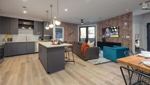 A modern kitchen with a central island, dark cabinetry, and pendant lighting.