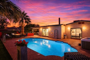 Ein modernes Haus mit Schwimmbad, Sitzgelegenheit im Freien und Whirlpool.