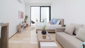 Ein modernes Wohnzimmer mit einer Couch, einem Couchtisch und einem Bett mit Blick ins Freie.