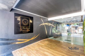 A modern interior with a logo for 'A Perfect Place at 141ST' and a wooden floor. - Oceanview Infinity Pool, Steps to 5th Ave & Beach (Playa del Carmen)