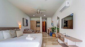 A hotel room with a bed, bedside table, lamp, wardrobe, and a mirror. - Chic Retreat with Oceanview Roof Pool Near 5th Ave (Playa del Carmen)