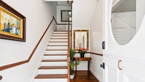A staircase with wooden steps and a white wall. - 6C at Saint Philip Square, One Block to King, Classic Charleston Comfort (Charleston)