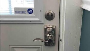 A white door with a silver doorknob and a window above it.