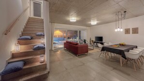 Un interior moderno con una escalera, un comedor y un espacio de sala.