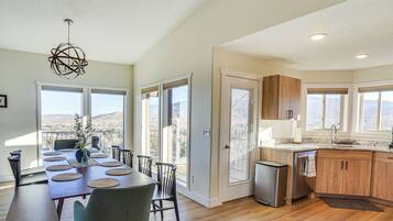 A spacious kitchen with a dining area, large windows, and a view of the mountains.