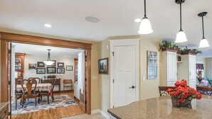 A kitchen with granite countertops, wooden chairs, and a dining area with a floral rug. - Charming Manchester Retreat w/ Patio & Fireplace! (Manchester)