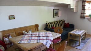 Un'accogliente zona giorno con un tavolo di legno, un divano e un piccolo tavolino in legno.