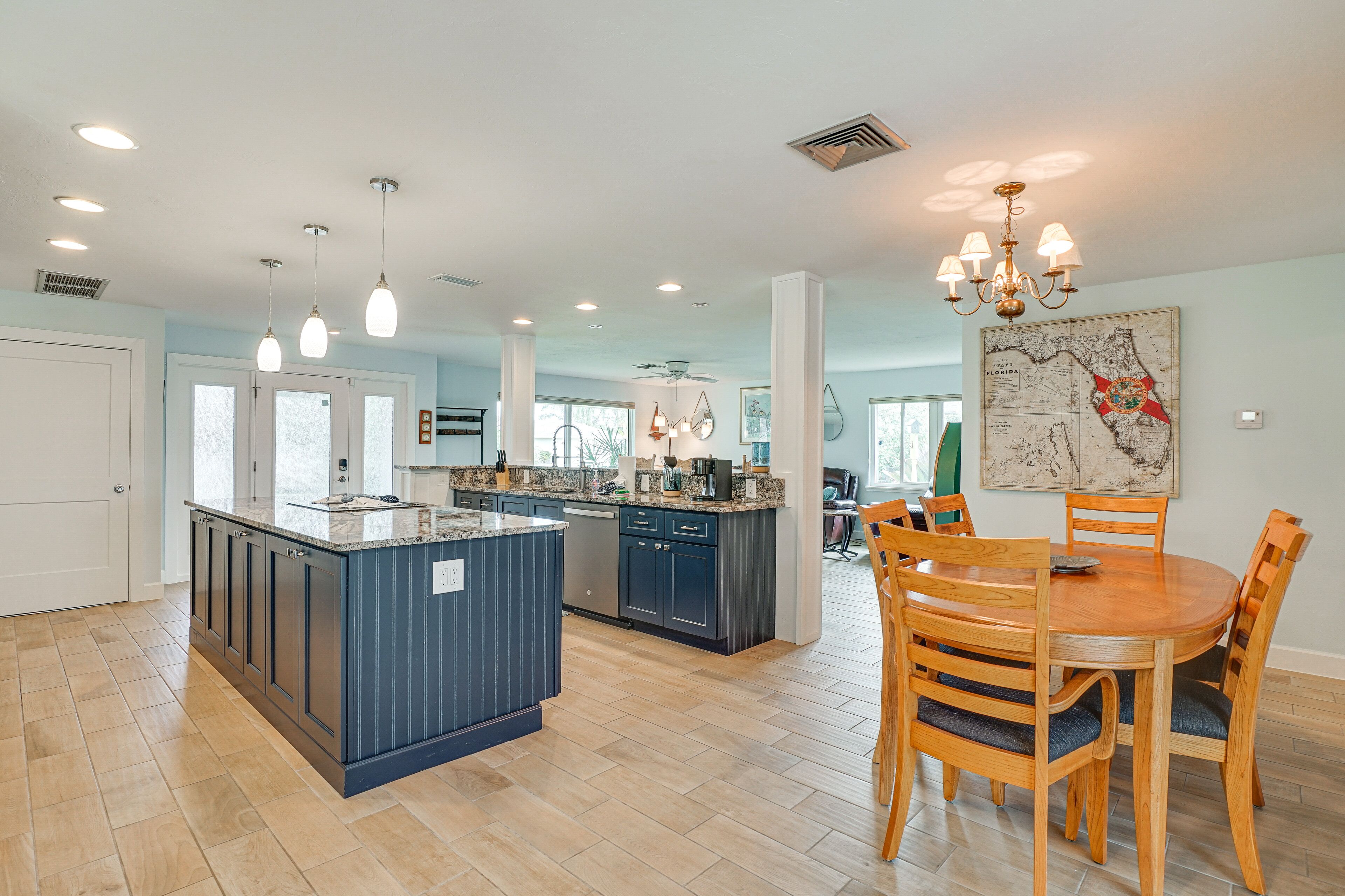 Una cocina amplia con una isla central, mesa de madera y sillas.