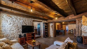 A rustic interior with stone walls, wooden beams, a flat-screen TV, a billiards table, and a cozy seating area. - Awesome home in Polaca (Polaca)