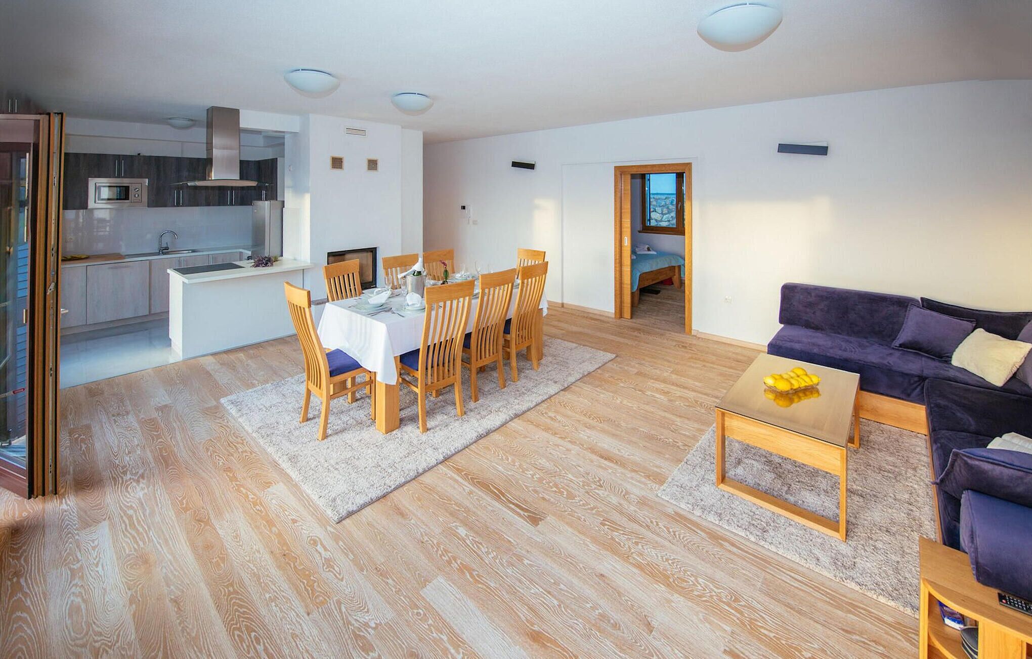 Un espacio habitable moderno con comedor, cocina y sofá.