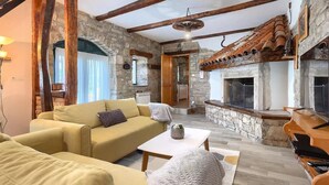 A cozy living room with a stone fireplace, a sofa, and a coffee table.