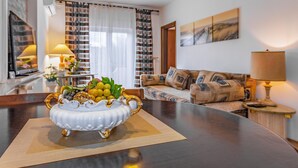 Een woonkamer met een ronde tafel, een bank en een lamp.