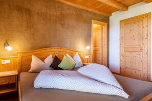 Una cama de madera con cabecera, mesitas de noche y una puerta de madera.