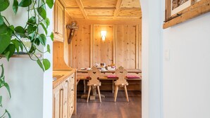 A wooden interior with a dining table and chairs, a wall-mounted light, and a wooden ceiling. - Apartment 'Ronsolhof Santner' with Mountain View, Shared Garden and Wi-Fi (Castelrotto BZ)