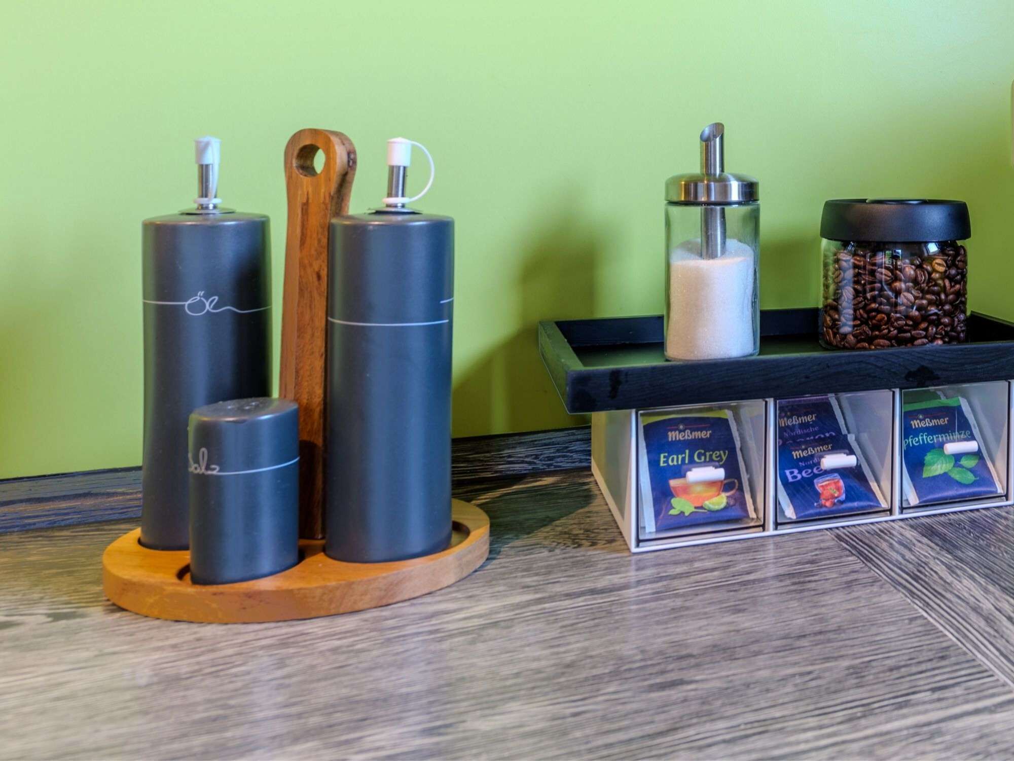 Un espai de cafè amb dispensadors, un recipient de sucre i un bocal per conservar els cafè.