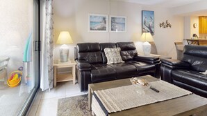 A living room with a sofa set, a coffee table, and a dining area.