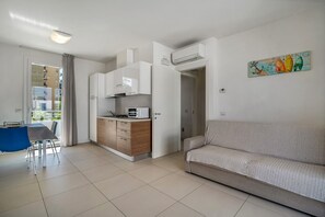 A modern apartment with a kitchenette, dining area, and a living room with a sofa.