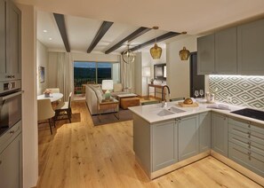 Een moderne keuken met grijze kastjes, een centraal eiland en een eethoek met uitzicht op de omgeving.