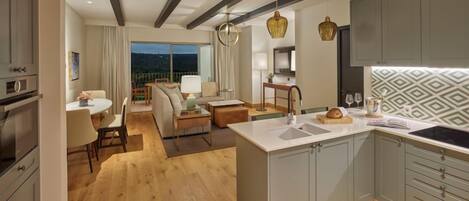 A modern kitchen with a central island, grey cabinets, and a patterned backsplash.