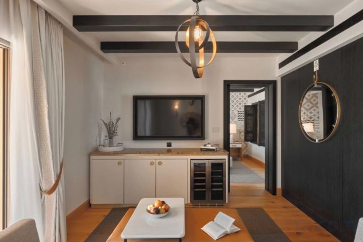 A modern living room with a flat-screen TV, a wooden coffee table, and a sofa.