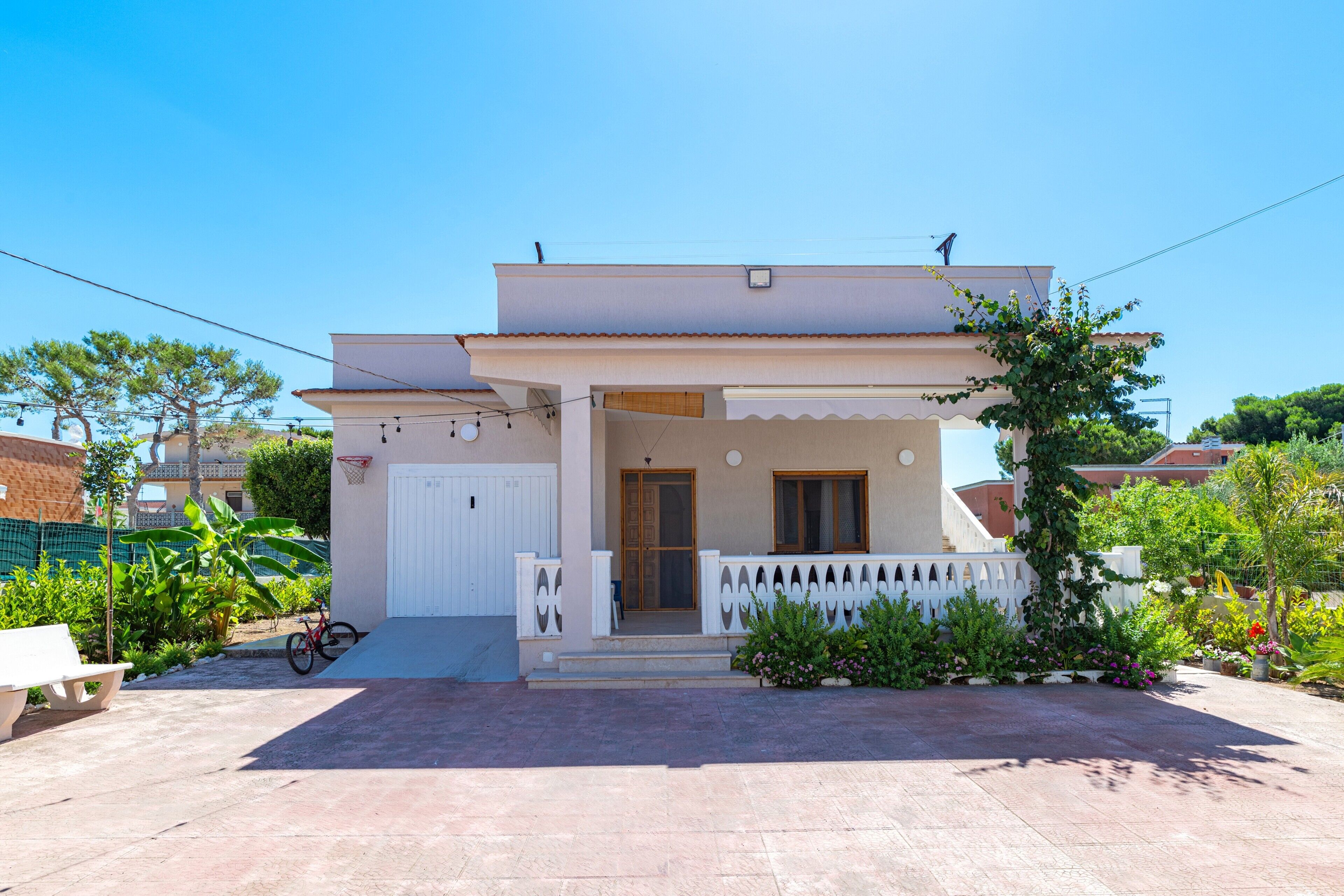 Una casa a due piani con un balcone, un ingresso e un piccolo portico.