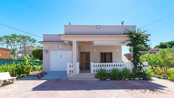 Una casa a due piani con un balcone, un ingresso e un piccolo portico.