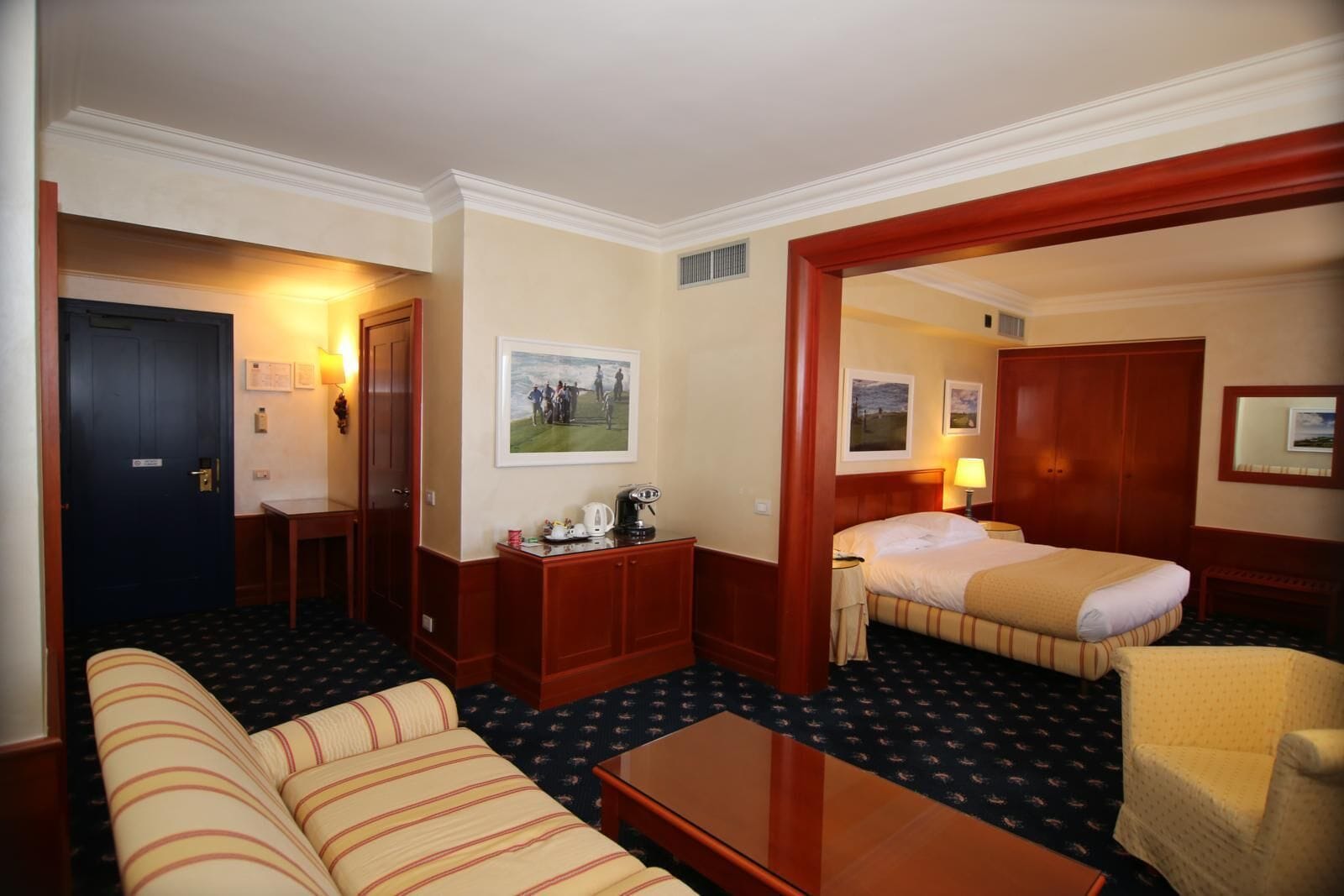 Une chambre d’hôtel avec un lit, un canapé, un bureau et une chaise.