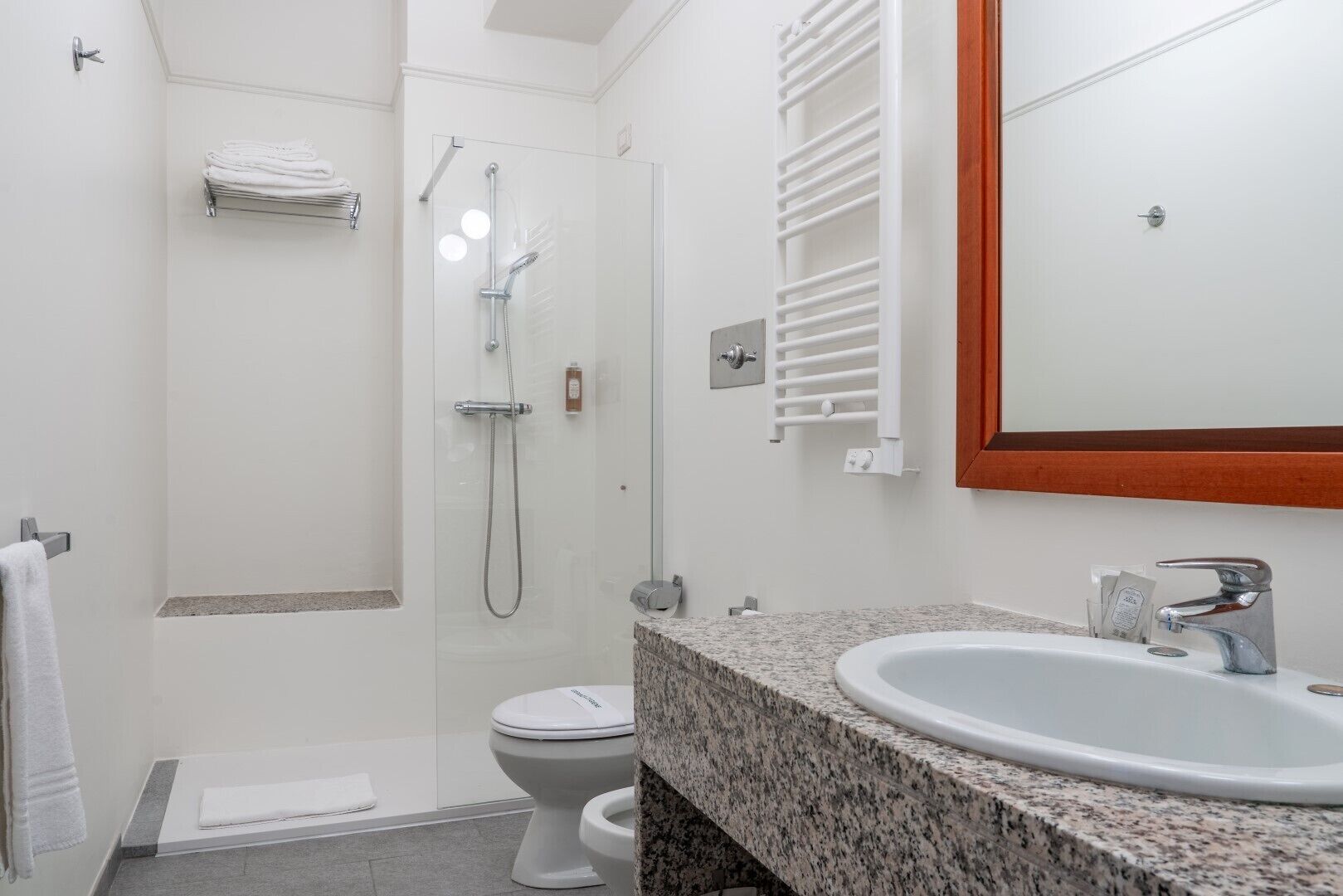 Une salle de bain moderne équipée d’une douche, de toilettes et d’un lavabo.