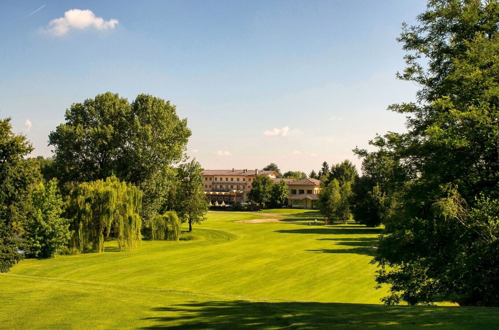 Ein Golfplatz mit einem großen Gebäude im Hintergrund.
