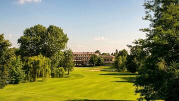 Ein Golfplatz mit einem großen Gebäude im Hintergrund.
