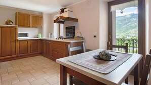 Une cuisine avec des meubles de rangement en bois, un four à micro-ondes et une cuisinière.