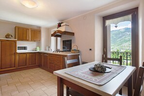Una cocina con armarios de madera, un microondas y una estufa.