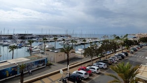 A marina with boats, a parking lot, and a building with a mural.