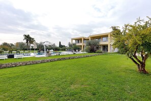 Un bâtiment moderne doté d’un toit plat, entouré d’une pelouse bien entretenue et de quelques arbres.