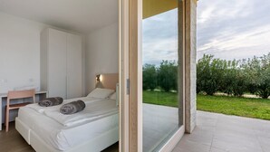 Une chambre à coucher avec un lit, un bureau et une vue sur l’extérieur.