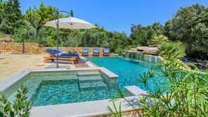 A swimming pool with clear blue water, surrounded by lounge chairs and a stone wall. - Gorgeous home in Ugljan (Ugljan)