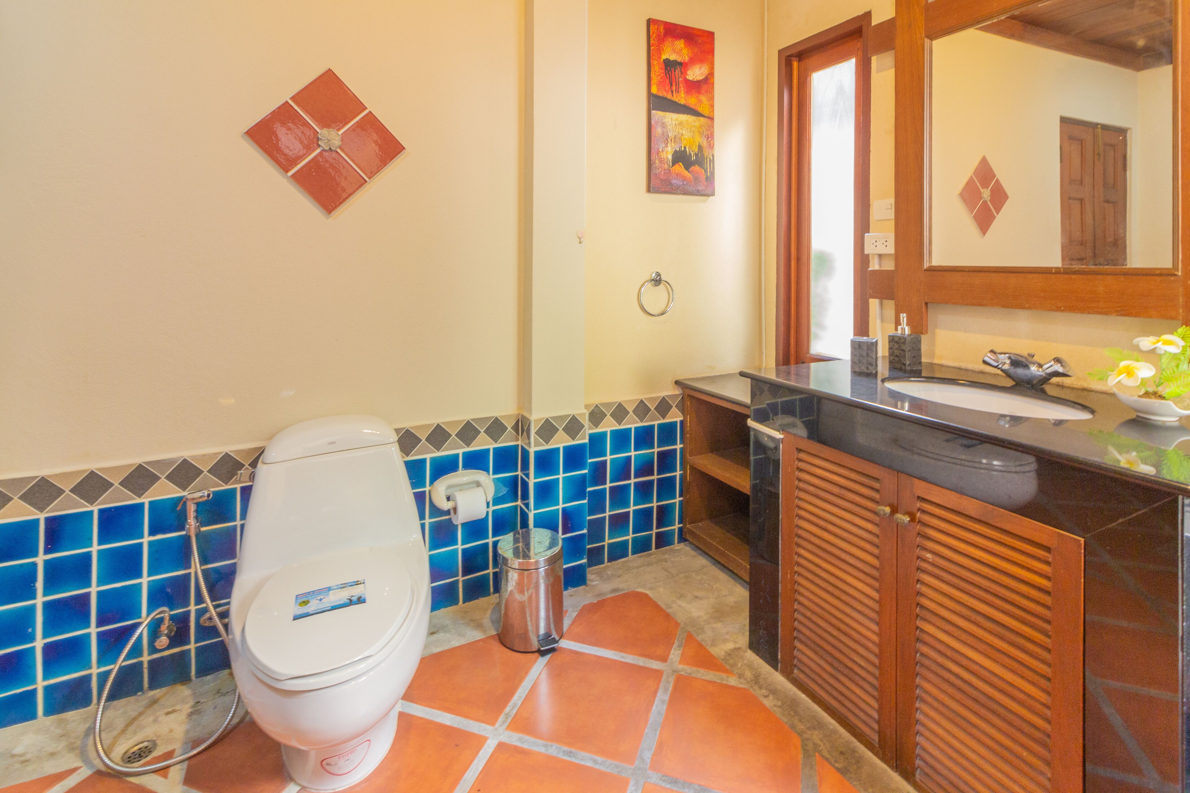 A bathroom with a toilet, sink, and tiled walls.