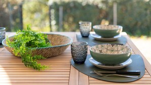 A dining table with a woven basket, a glass, and patterned bowls. - Holiday Home "Nuages" with Shared Pool and Private Terrace (Badesi)