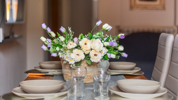 A dining table set with plates, glasses, and a centerpiece of flowers. - Apartment 'Mirasole House' with Wi-Fi and Air Conditioning (bologna)