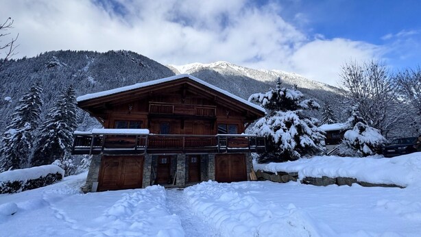 A wooden cabin with a stone foundation, surrounded by snow-covered trees and mountains. - Half-chalet facing the Bossons and Taconnaz glaciers (Chamonix Mont Blanc)