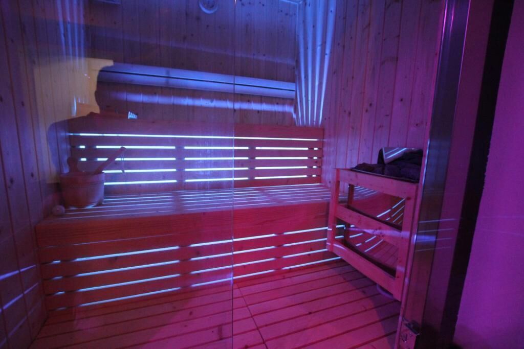 A sauna with wooden benches and a bench with a shelf.