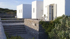 A modern white building with a stone staircase leading to a door, surrounded by greenery. - Gorgeous Villa an Oasis for 8 (Paros)