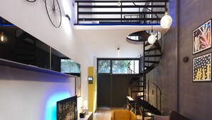 A modern interior with a staircase, a flat-screen TV, a yellow armchair, and artwork on the walls. - 200mb Fibre Remote Workers' Dreamhouse (Athens)