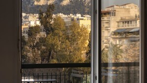 A room with a large window overlooking a cityscape and a pool table. - A Truly WOW Experience for Every Guest (Athens)