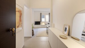 Et moderne køkken med en central ø, indbygget ovn og et vindue med gardiner.